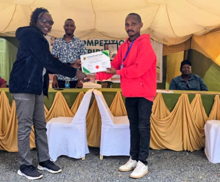 Mrs Joyce M,ibari,receiving a certificate of participation on behalf of the tribunal from a representative of the A.S.K